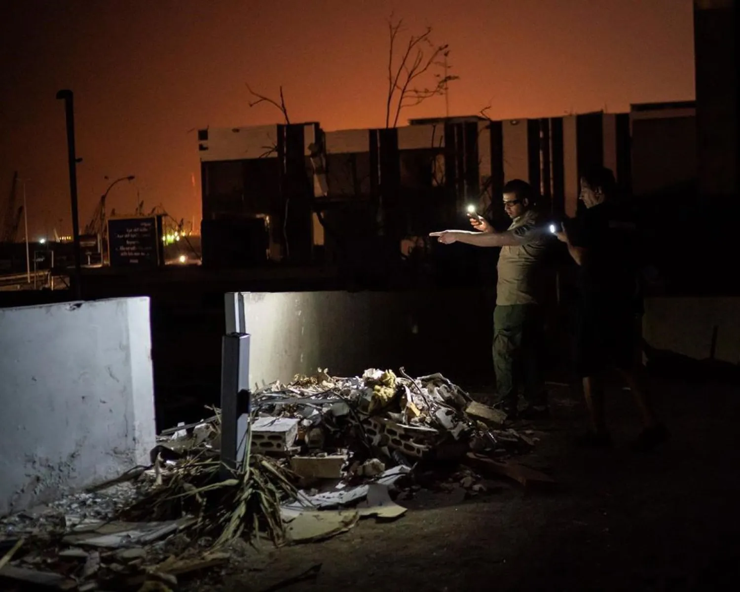 Kamal Khatib, of Animals Lebanon, and a security guard look for a family of cats hiding among debris of a damaged building near the site of last week's explosion in Beirut, Lebanon, Aug. 13, 2020. (AP)