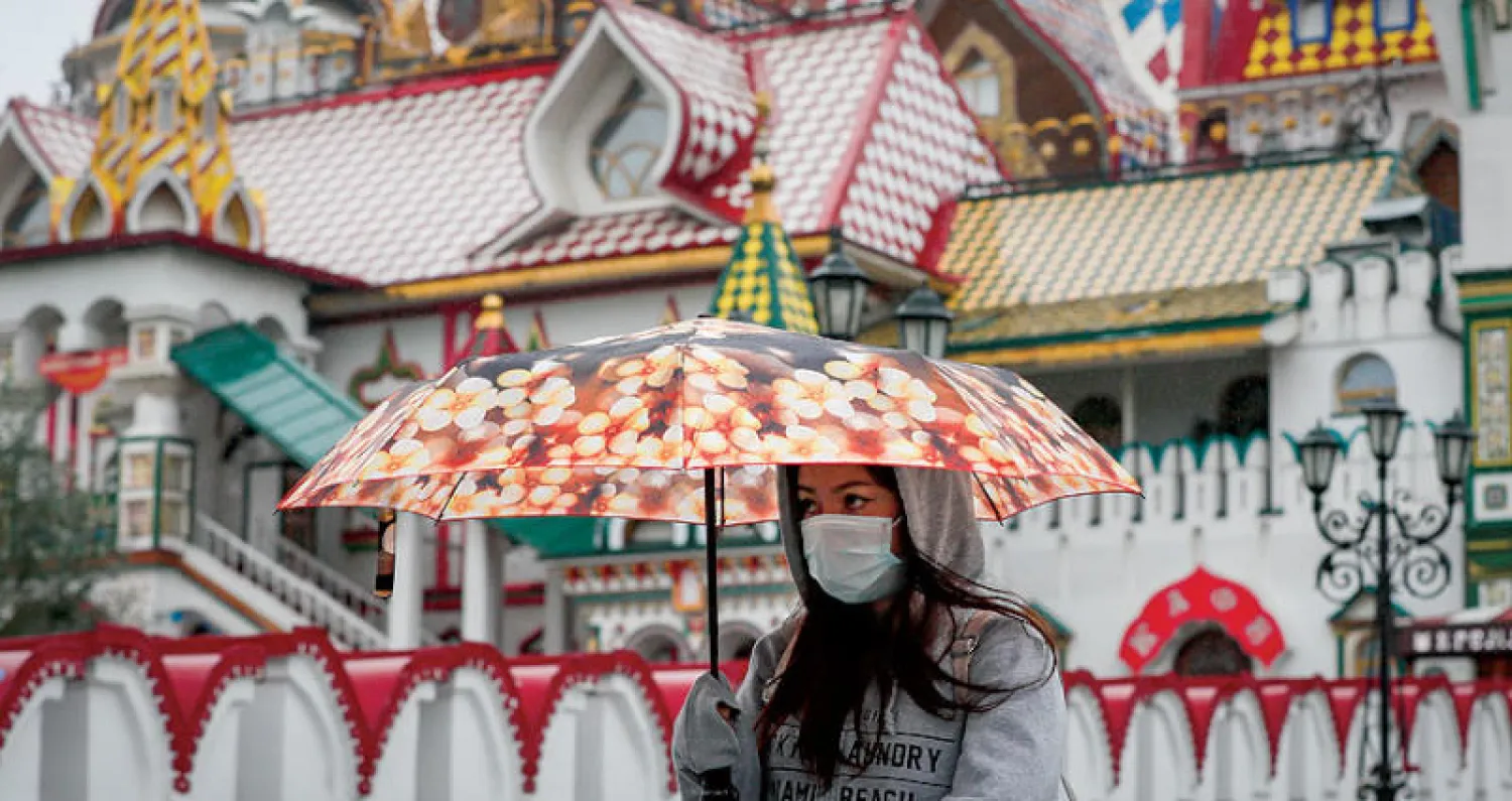 سيدة تضع كمامة واقية في منطقة سياحية بموسكو أمس (إ.ب.أ)