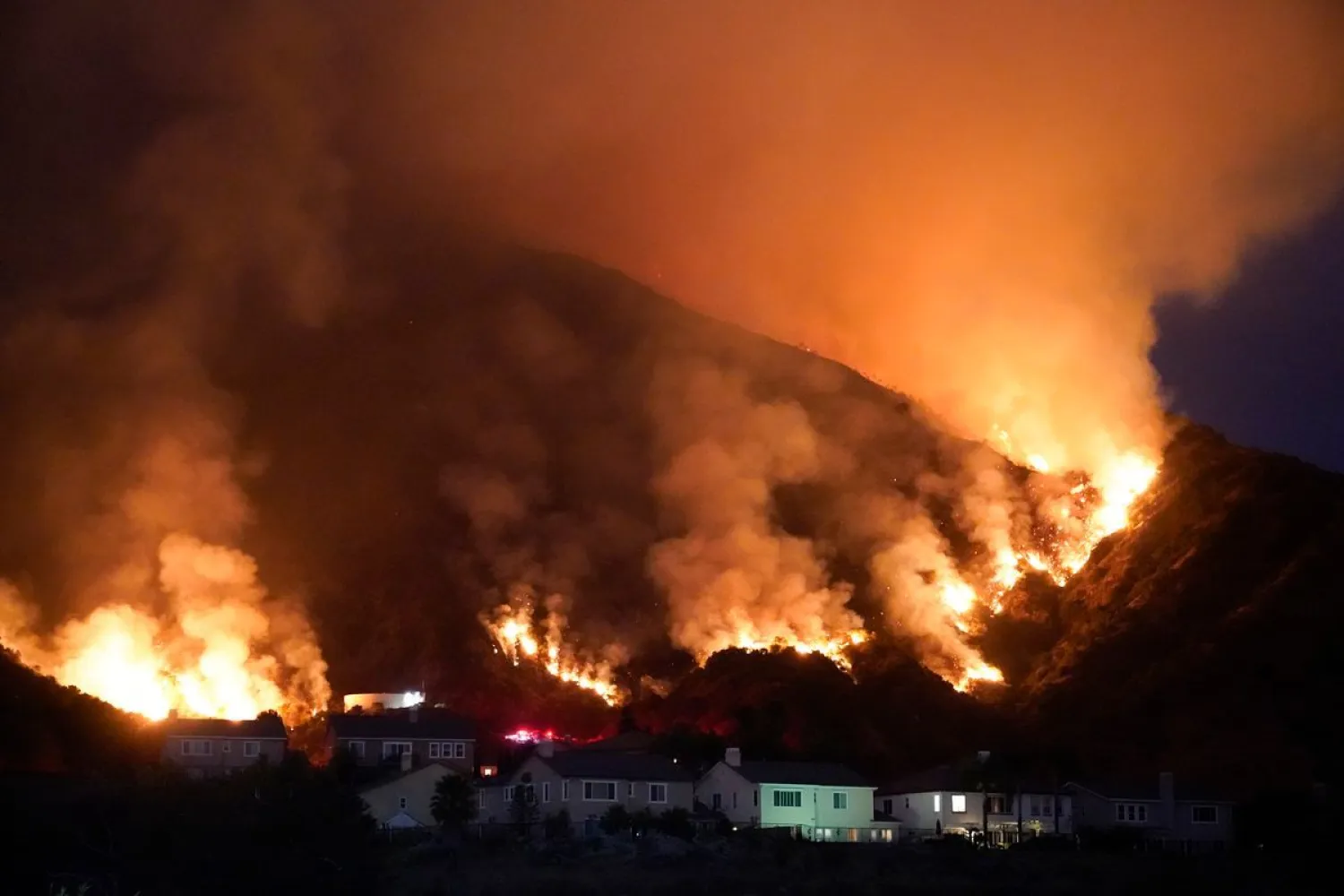 The Ranch Fire burns over a residential area, Thursday, Aug. 13, 2020, in Azusa, Calif. Heatwave conditions were making difficult work for fire crews battling brush fires and wildfires across Southern California. (AP Photo/Marcio Jose Sanchez)