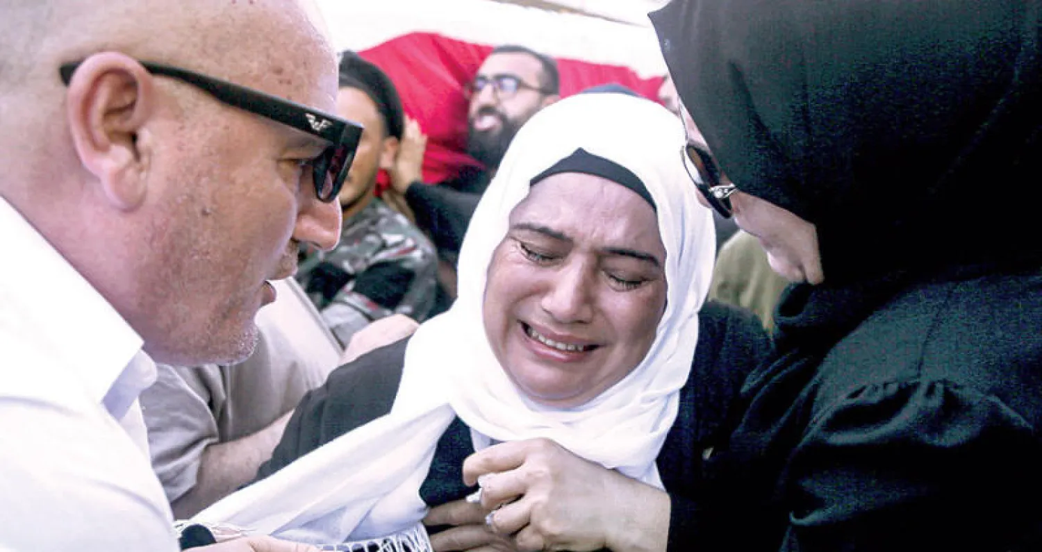 والدة إطفائي قُتل في انفجار مرفأ بيروت تبكي خلال جنازته أمس (د.ب.أ)