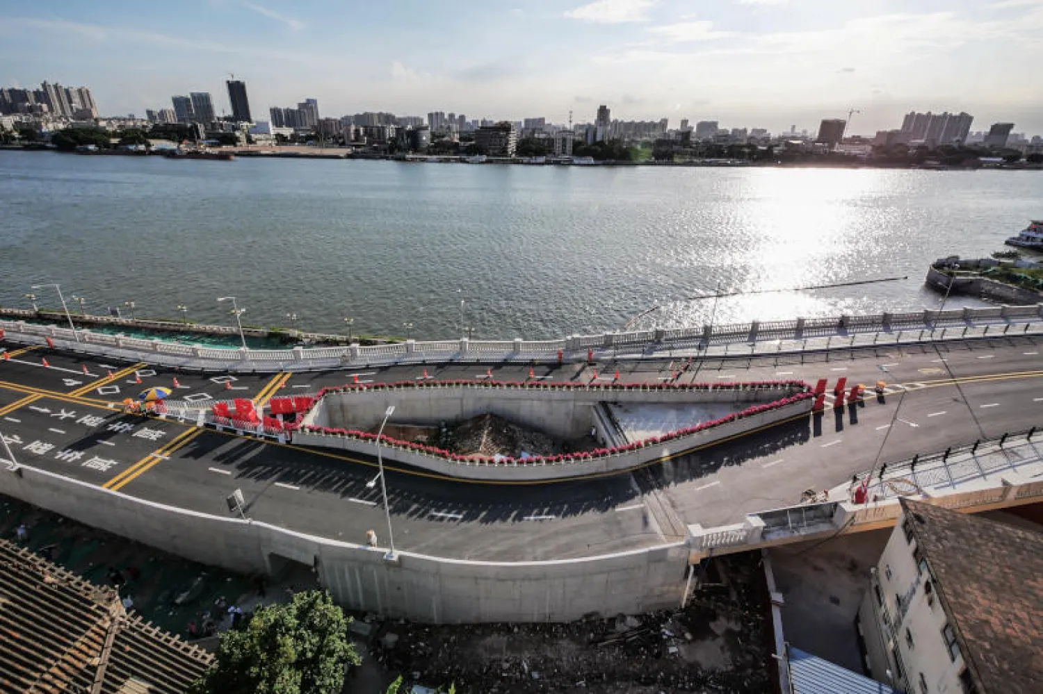 المنزل الواقع في منتصف طريق سريع يتقاطع مع ممر مائي صغير في مدينة غوانغزو (د.ب.أ)