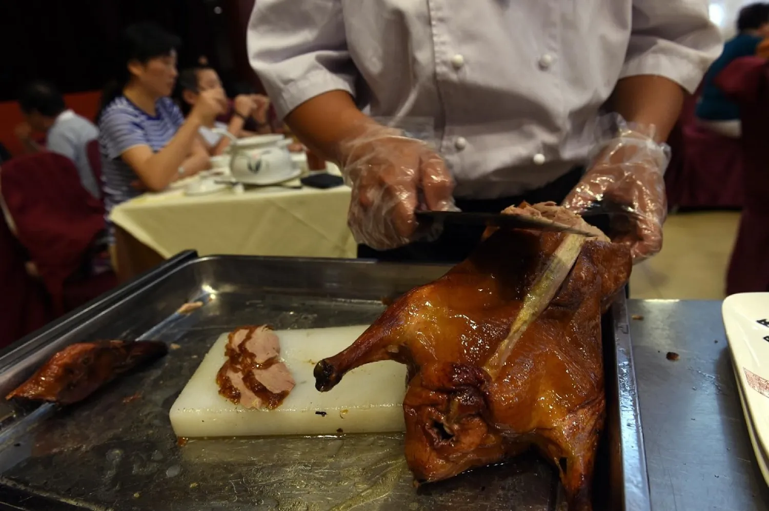 A chef slicing Peking Duck for diners at the Quanjude restaurant in Beijing. (AFP)