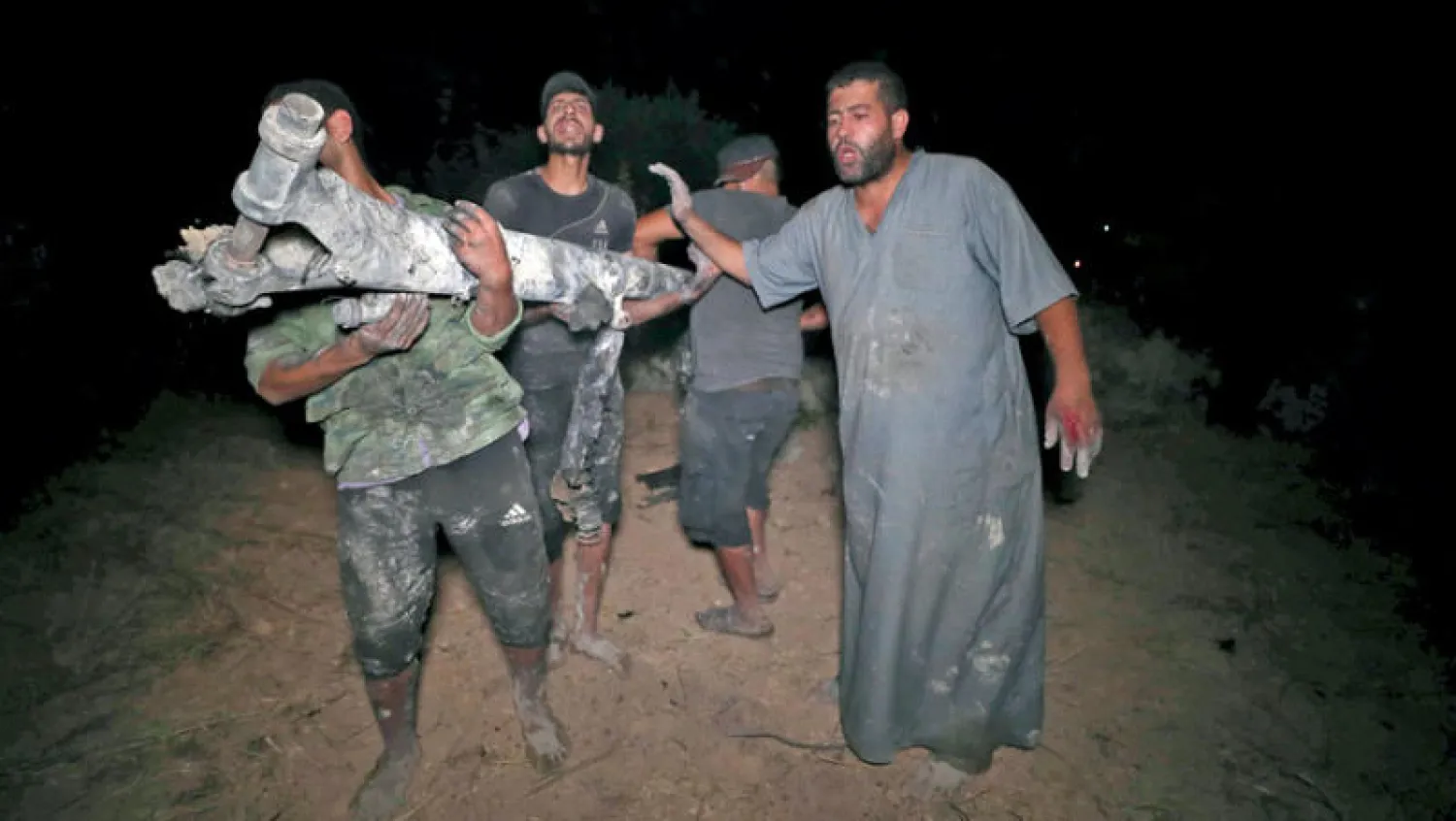 رجال يحملون حطام «درون» في شمال غربي سوريا (أ.ف.ب)