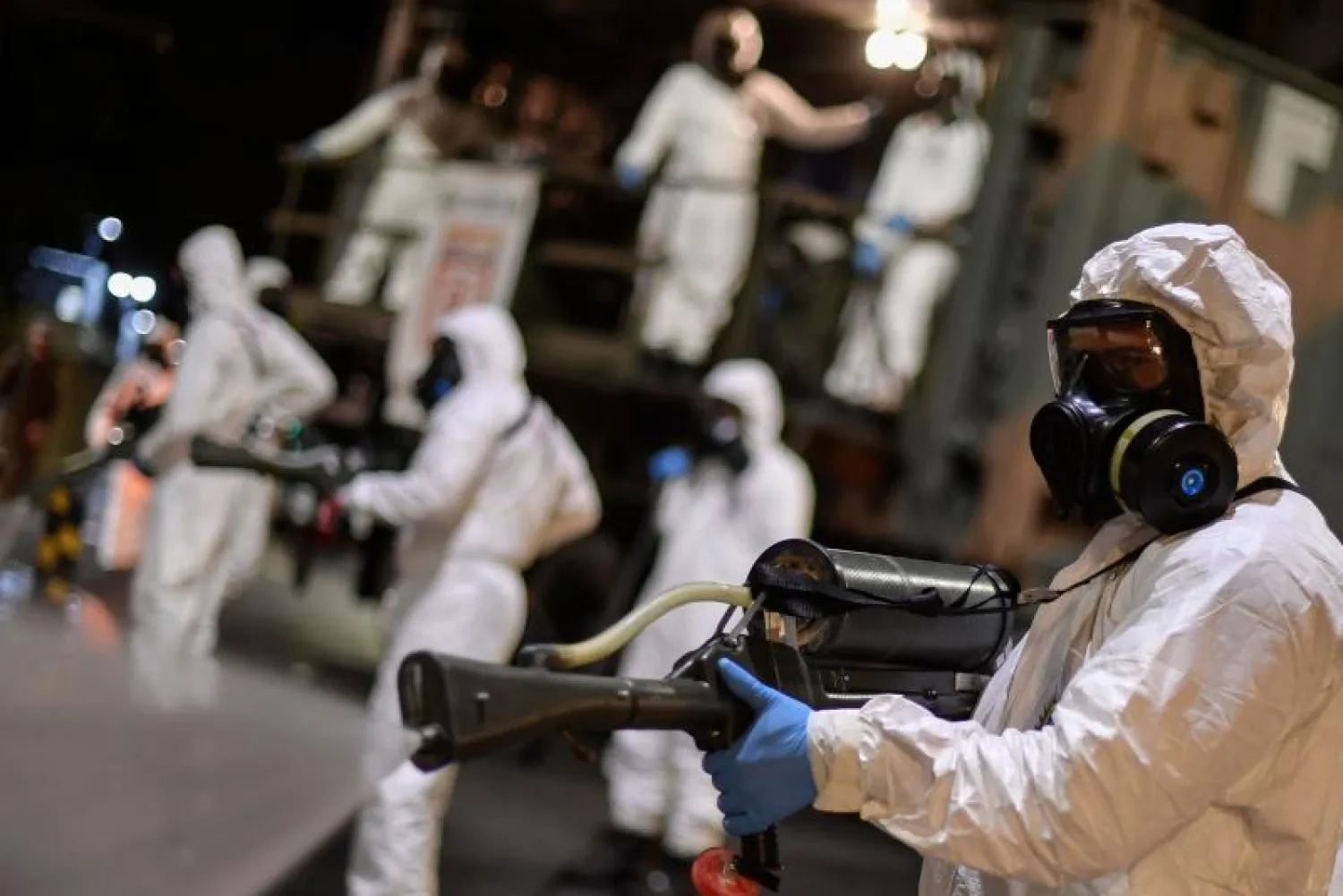 جنود من المنطقة العسكرية الرابعة للقوات المسلحة البرازيلية يشاركون في تنظيف وتطهير المنطقة الخارجية للسوق البلدية في بيلو هوريزونتي (أ.ف.ب)