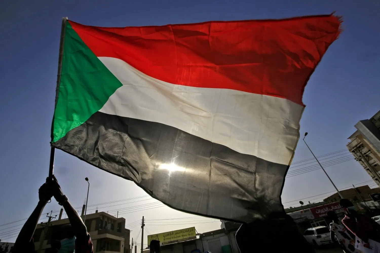 A protester waves a national flag during an anti-government demonstration in Khartoum in June 2020. (AFP)