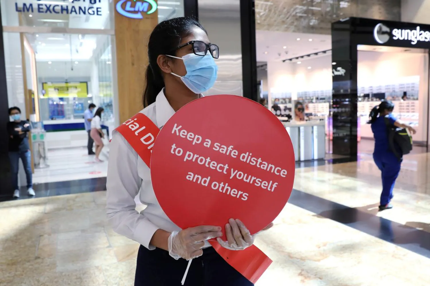 A woman holds a sign at Mall of the Emirates after the UAE government eased a curfew and allowed stores to reopen, in Dubai, United Arab Emirates May 5, 2020. (Reuters)