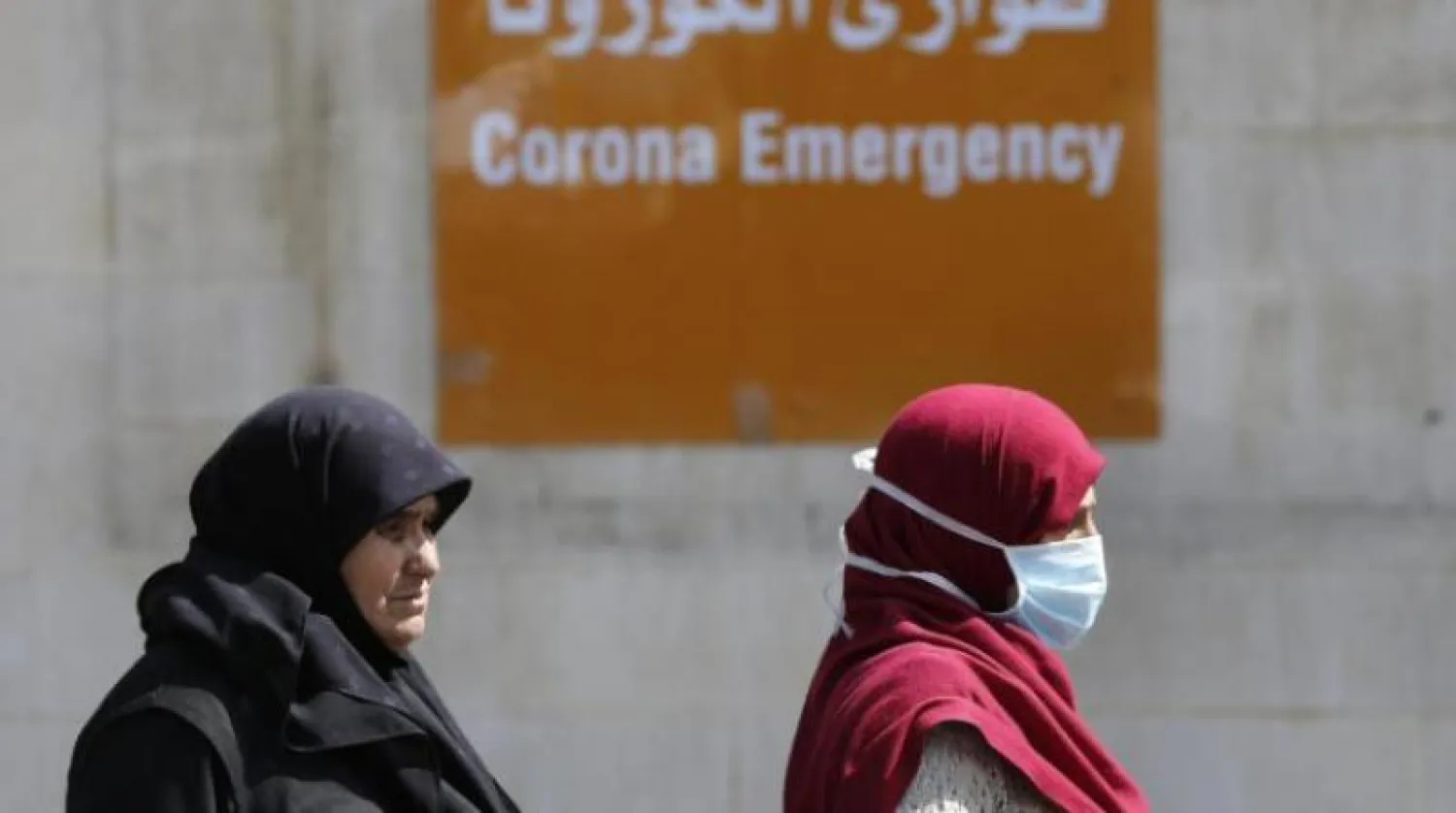 سيدتان تمران من أمام مدخل الطوارئ الخاص بمستشفى رفيق الحريري الجامعي في بيروت (أرشيفية-أ.ب)