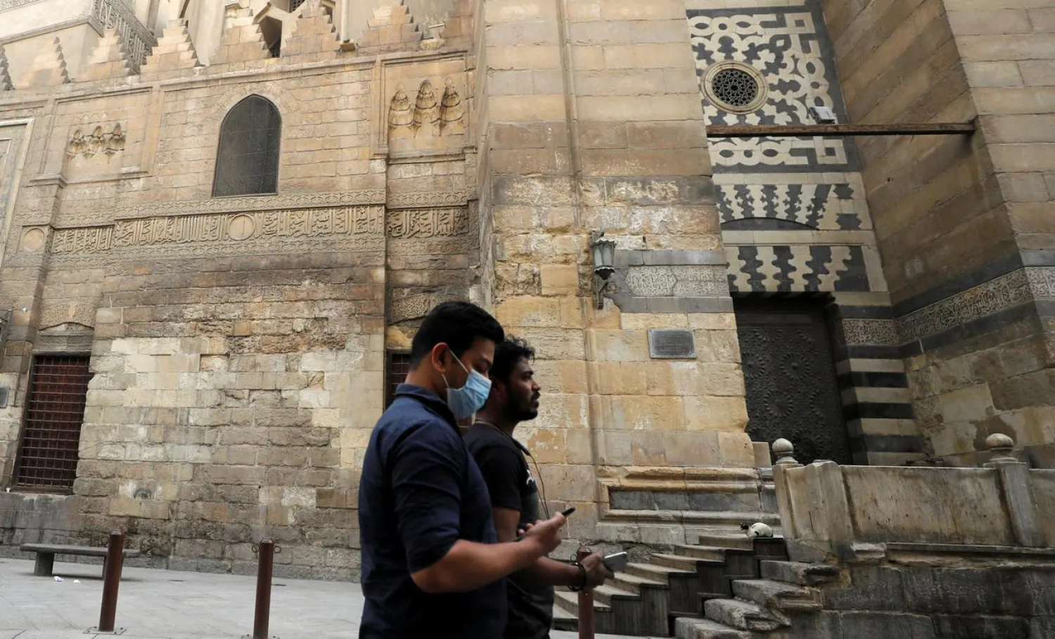 FILE PHOTO: Men are seen walking at Al Moez street in al-Hussein and al-Azhar district as mosques are closed in old Islamic Cairo, as Egypt ramps up efforts to slow the spread of coronavirus disease (COVID-19) in Cairo, Egypt, April 6, 2020. REUTERS/Mohamed Abd El Ghany/File Photo
