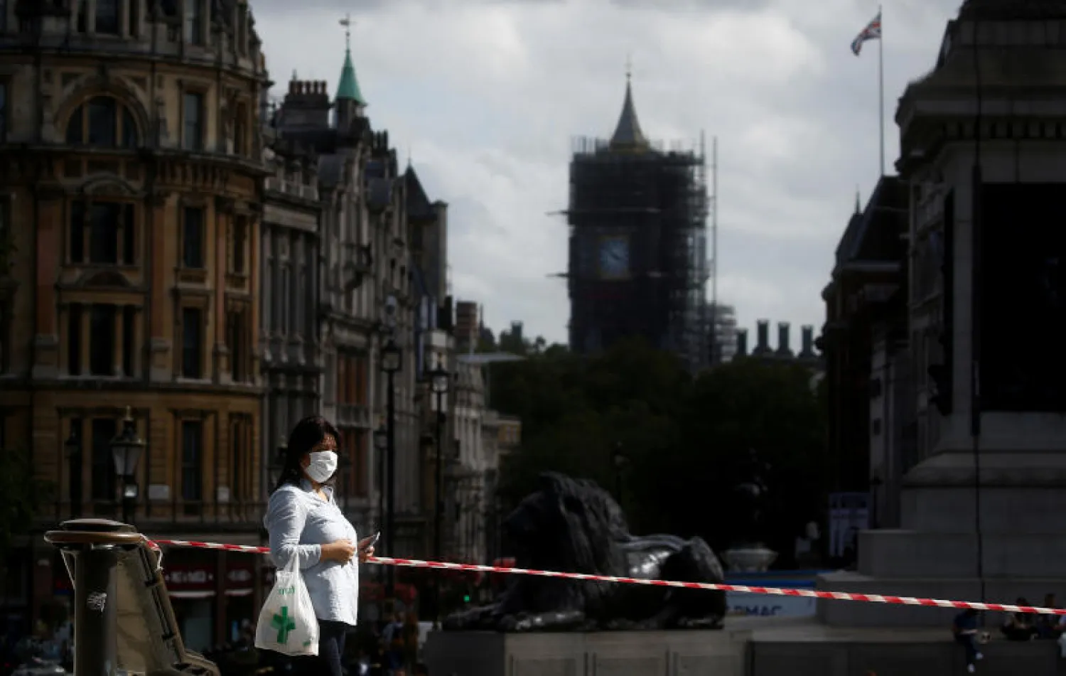 سيدة ترتدي قناعاً واقياً في لندن (رويترز)