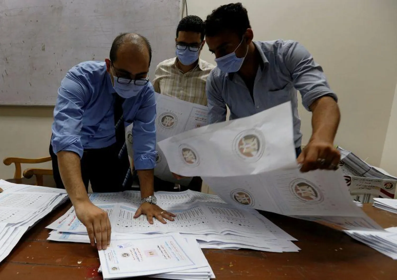 Election officials wearing protective face masks count ballots inside a school used as a polling station during Senate elections, Cairo, Egypt (Reuters)
