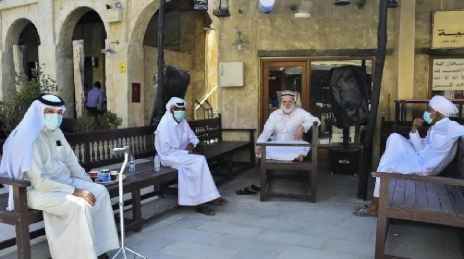 قطريون يجلسون خارج أحد المطاعم في «سوق واقف» بالدوحة (أ.ف.ب)