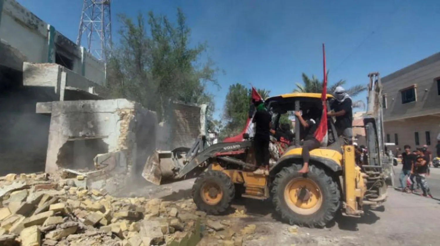 Protesters use a bulldozer to demolish offices of parties during ongoing anti-government protests in Nasiriyah, Iraq August 22, 2020. REUTERS/Stringer