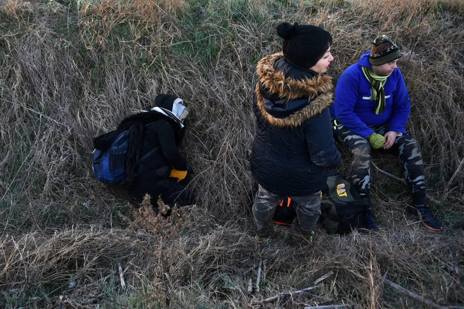 Migrants rest in a ditch, after crossing from Turkey to Greece, near the border crossing of Kastanies. (Reuters file photo)