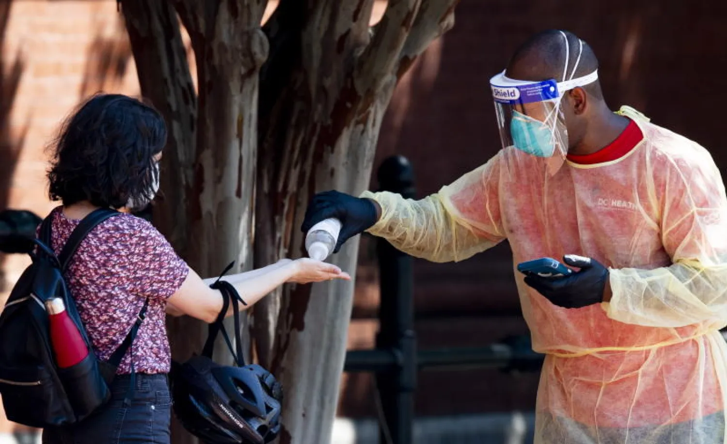 امرأة تعقّم يديها قبل خضوعها لاختبار الكشف عن «كورونا» في واشنطن (إ.ب.أ)