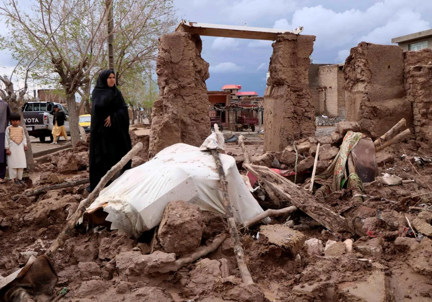 A woman stands next to her house destroyed by flood in Enjil district of Herat province, Afghanistan March 29, 2019. REUTERS/Jalil Ahmad