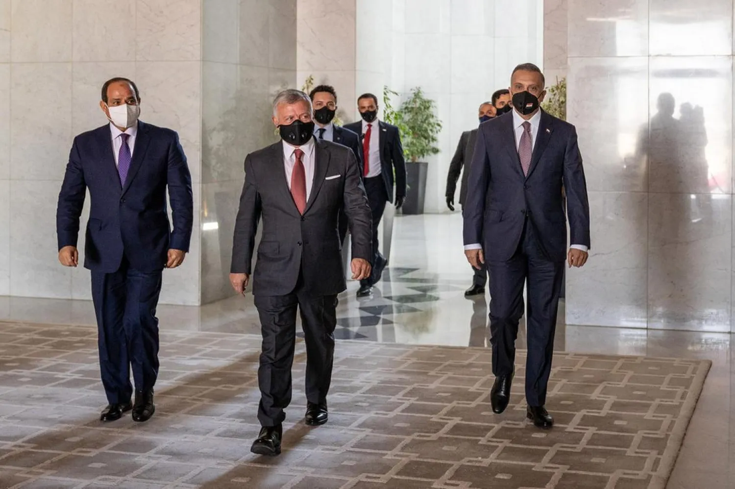 Jordan's King Abdullah II, center, arrives with Egyptian President Abdul Fattah al-Sisi, left, and Iraqi PM Mustafa al-Kadhimi, right, ahead of the summit in the capital Amman. (Jordanian Royal Palace – AFP)