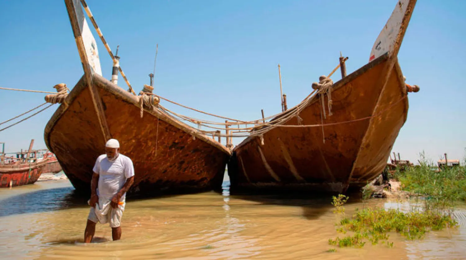 مزارع عراقي يتفقد منسوب المياه قرب أرضه في الفاو جنوب البصرة (أ.ف.ب)