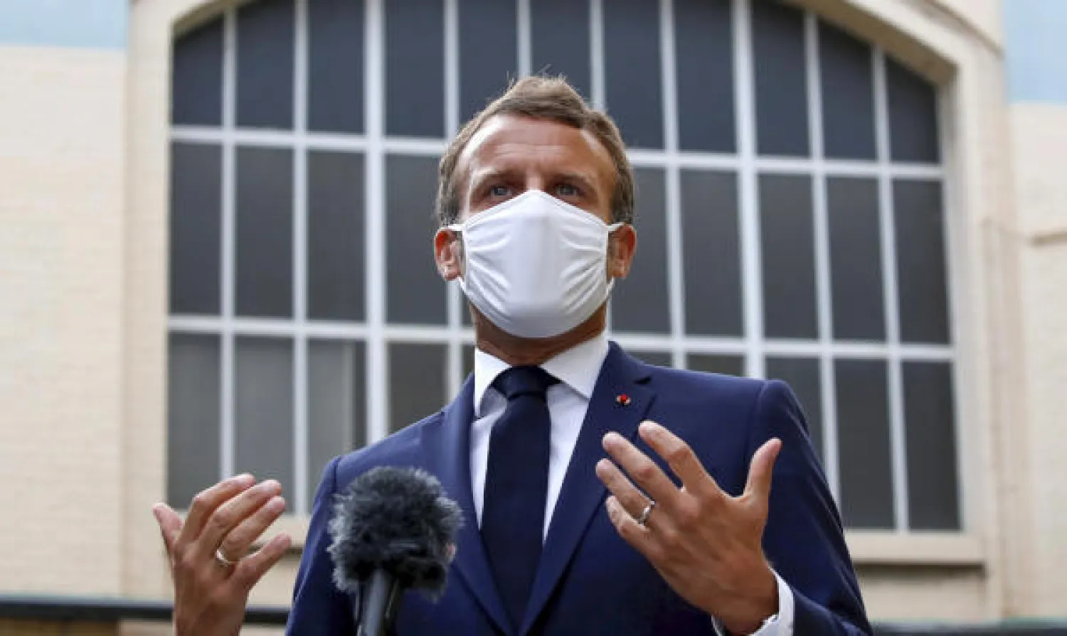 ماكرون مرتدياً كمامة واقية خلال زيارته لمقر مجموعة أدوية قرب باريس (أ.ب)