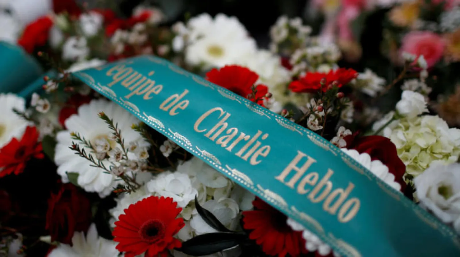 أكاليل من الورود خارج المكتب السابق لصحيفة «تشارلي إبدو» الساخرة في الذكرى الخامسة للهجوم وحصار سوبر ماركت «كوشير» الذي أسفر عن مقتل 17 شخصاً في باريس (رويترز)