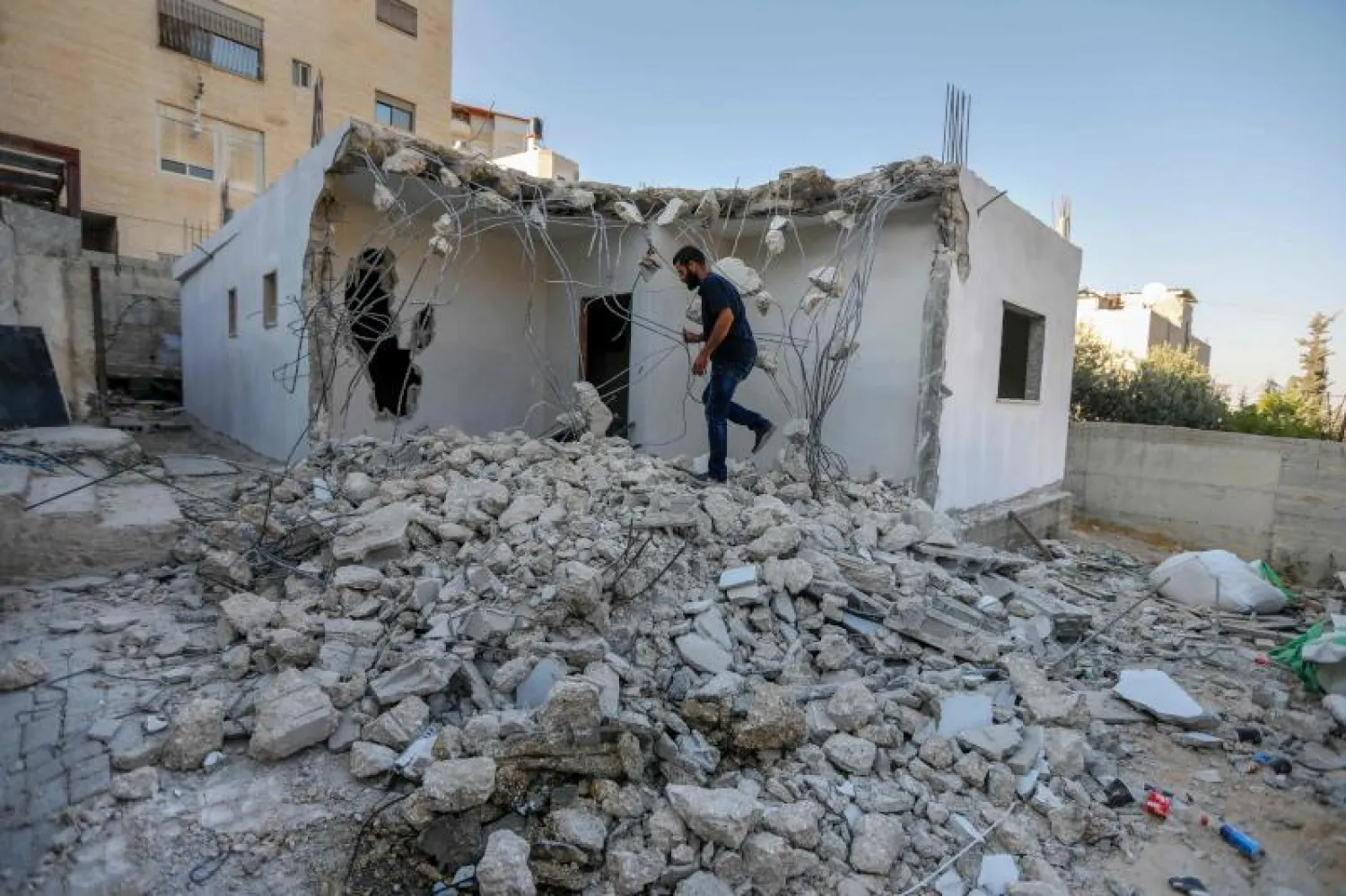 فلسطيني يقف وسط حطام منزله (أ.ف.ب)