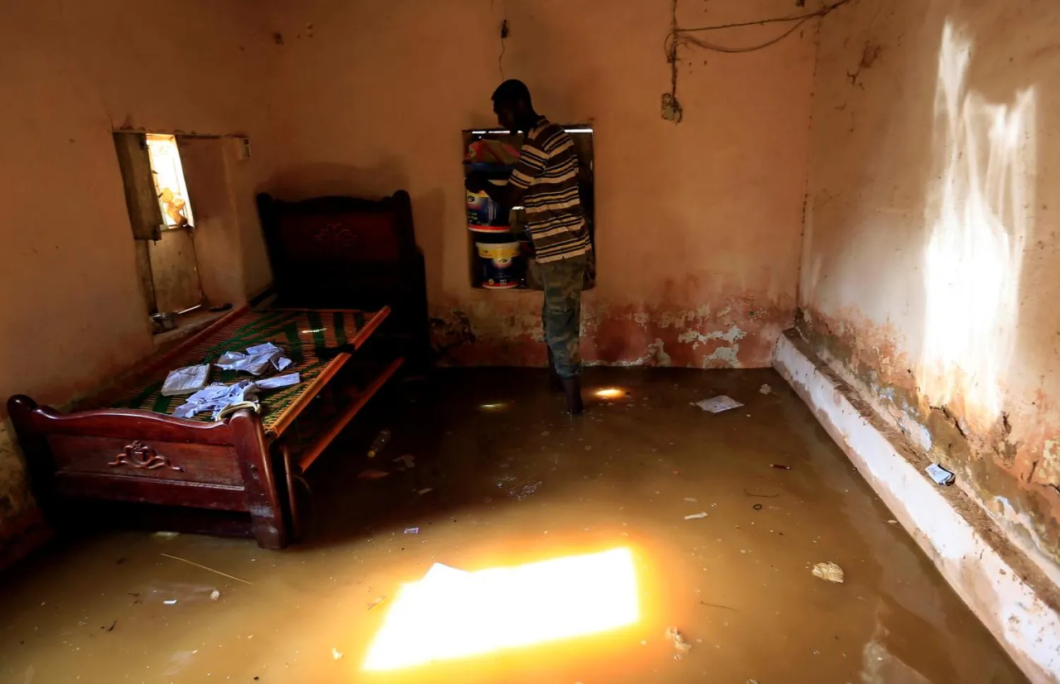 A resident secures his household property from the waters of the Blue Nile floods inside his house in the Al-Ikmayr area of Omdurman in Khartoum, Sudan August 27, 2020. REUTERS/Mohamed Nureldin Abdallah