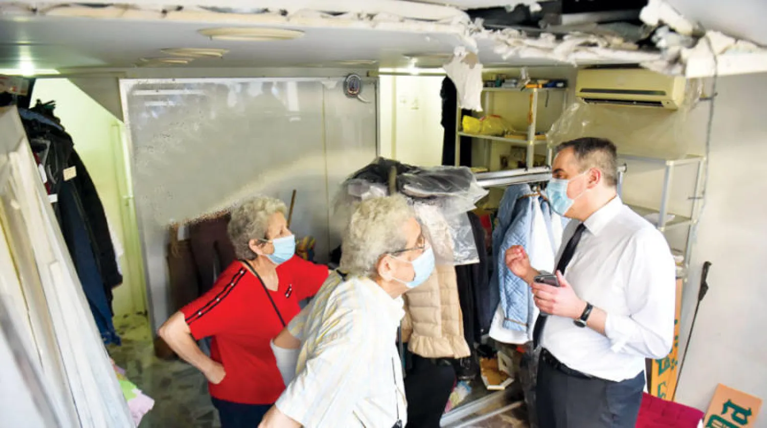 أديب متحدثاً مع صاحب منزل متضرر من انفجار مرفأ بيروت أمس (أ.ف.ب)