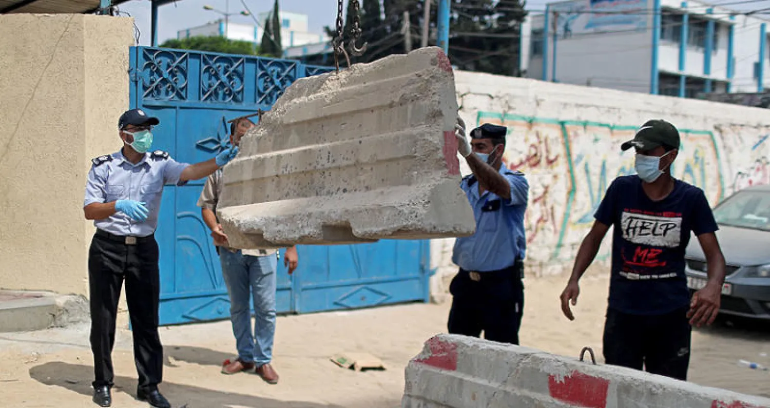 شرطة غزة تغلق شارعا في مخيم جباليا بعد قرار إغلاق القطاع بسبب كورونا (رويترز)