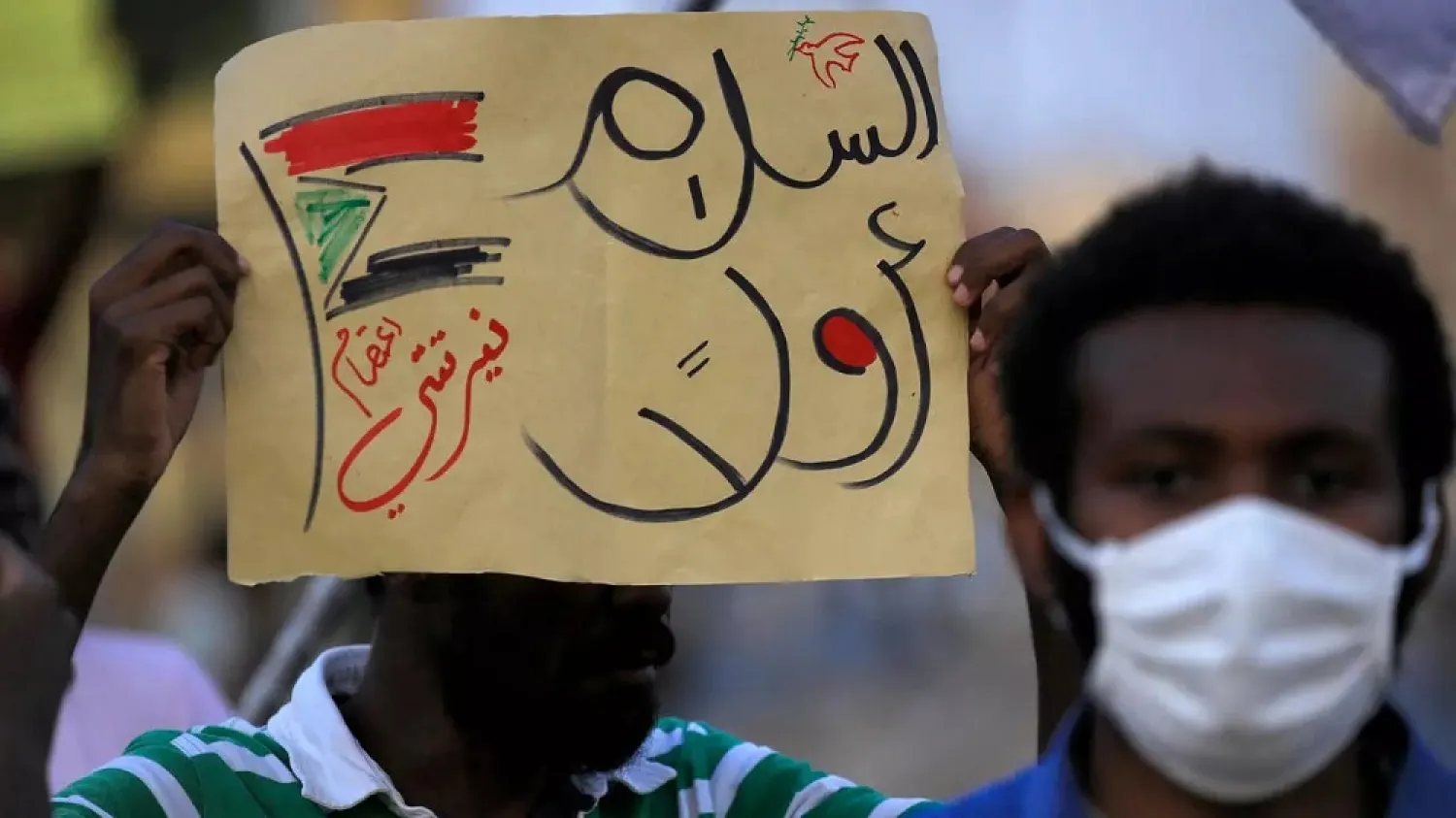 File photo taken July 4, 2020, of a demonstrator holding up a sign reading in Arabic ‘peace first’ during a protest in Khartoum, Sudan. (AFP)