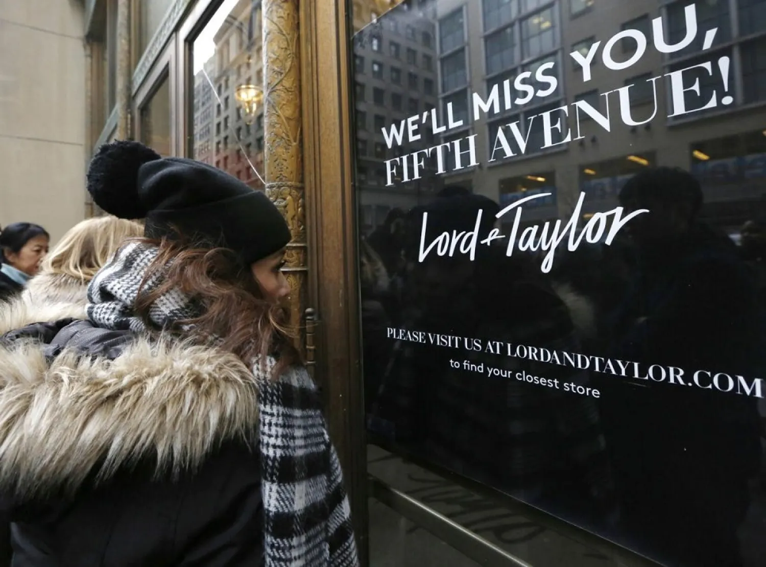 In this Jan. 2, 2019 file photo, women peer in the front door of Lord & Taylor's flagship Fifth Avenue store which closed for good, in New York. (AP)