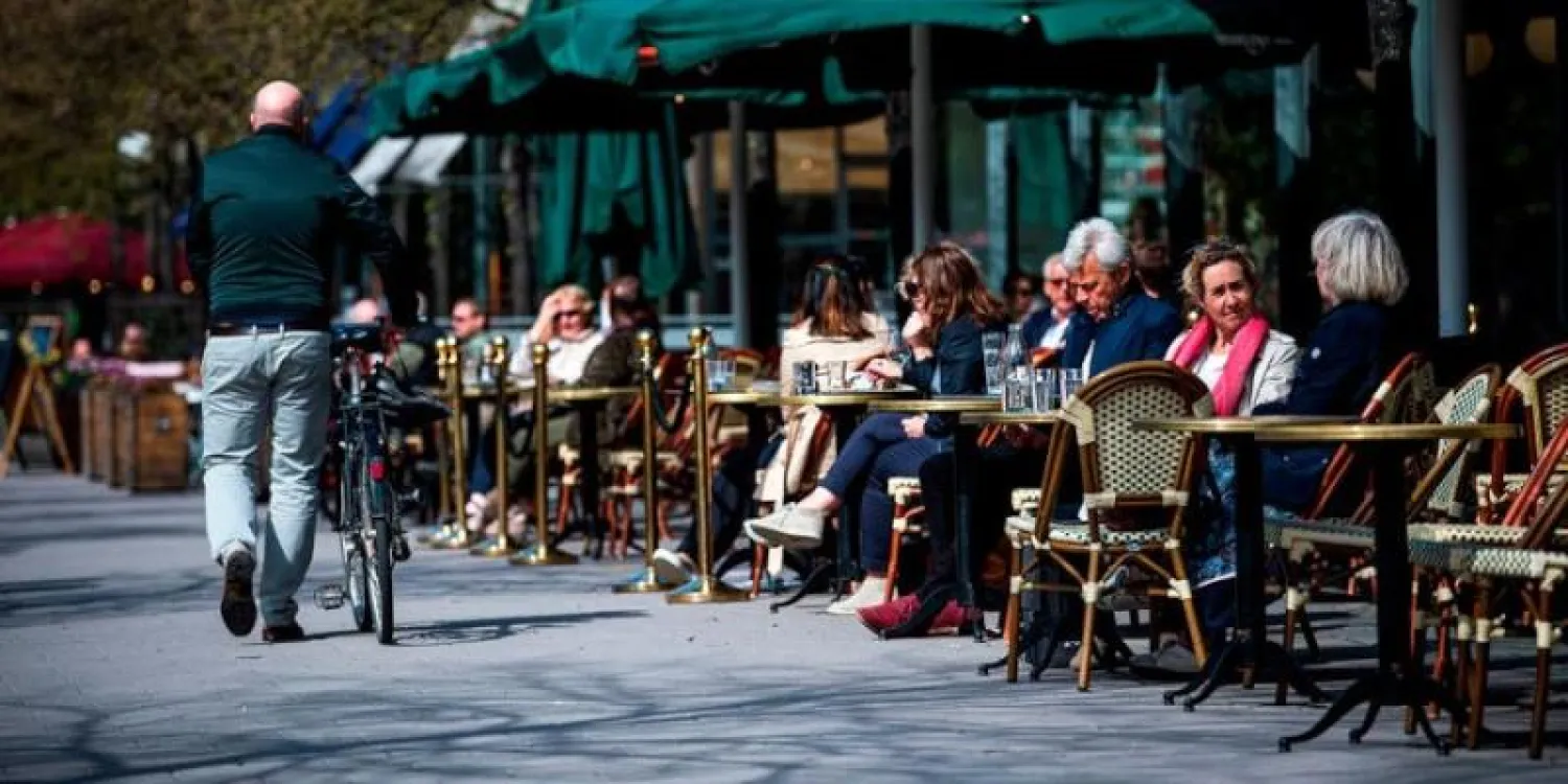 أشخاص يجلسون في مطعم بالسويد التي تعتبر أولى الدول المطبقة لاسترايجية مناعة القطيع (أ.ف.ب)