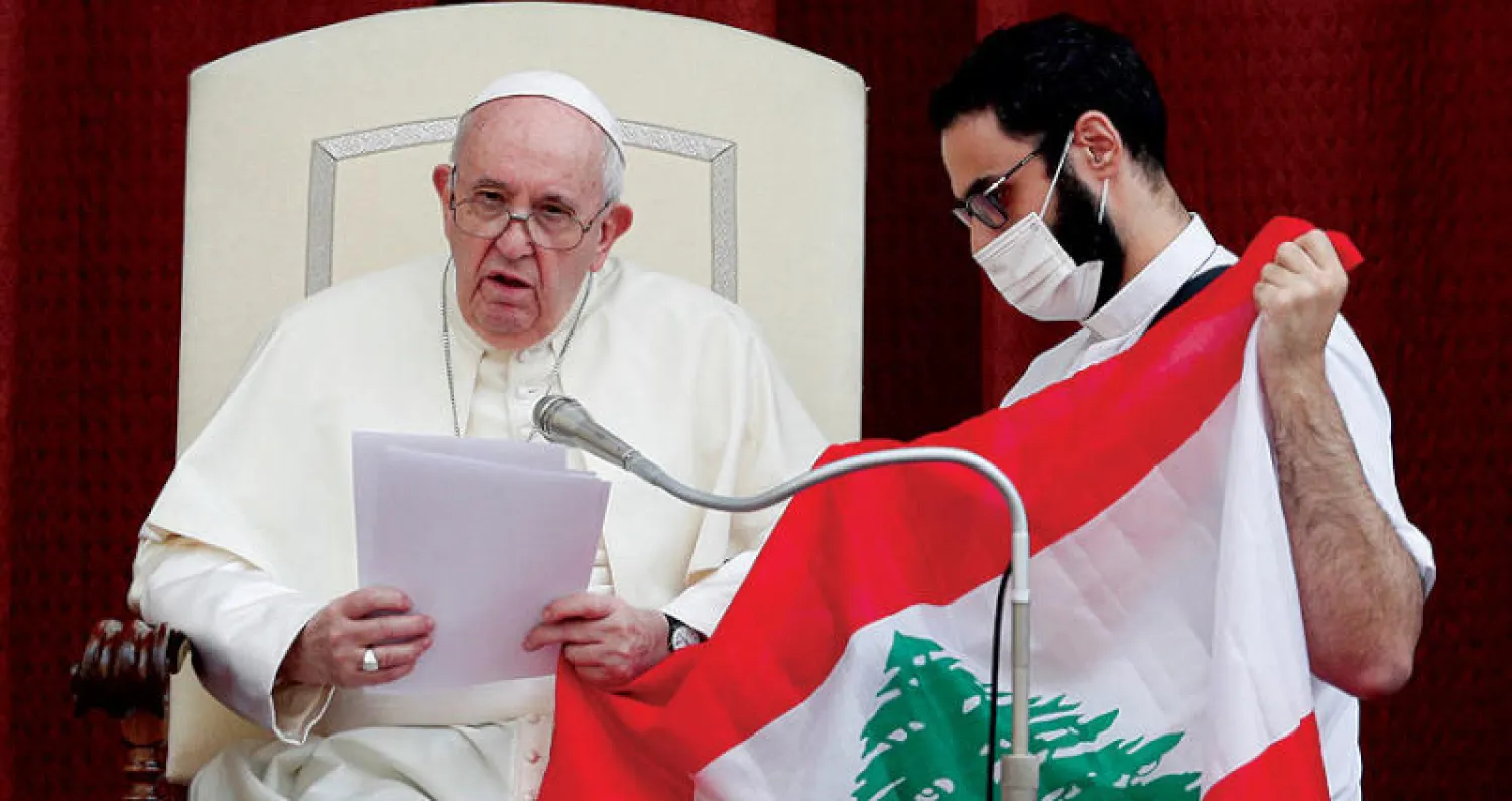 البابا يوجه نداءه أمس وإلى جانبه رجل دين يحمل العلم اللبناني (رويترز)