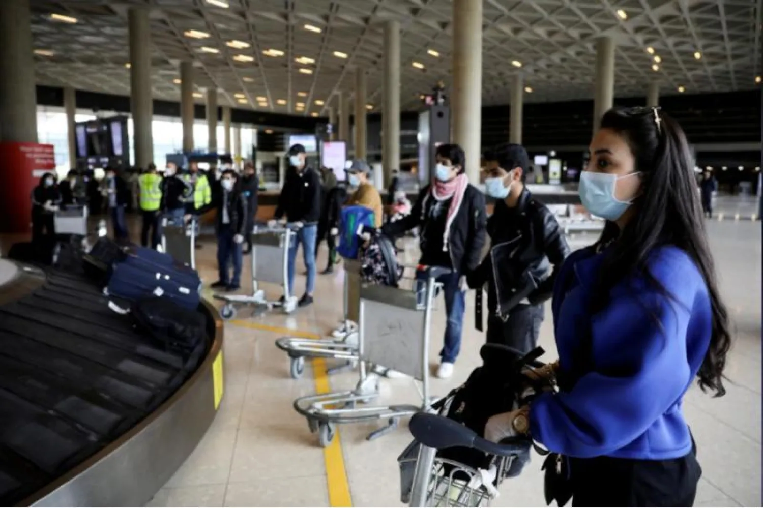 طلاب أردنيون عائدون إلى وطنهم ينتظرون أمتعتهم بمطار الملكة علياء الدولي في عمّان (أرشيفية - رويترز)