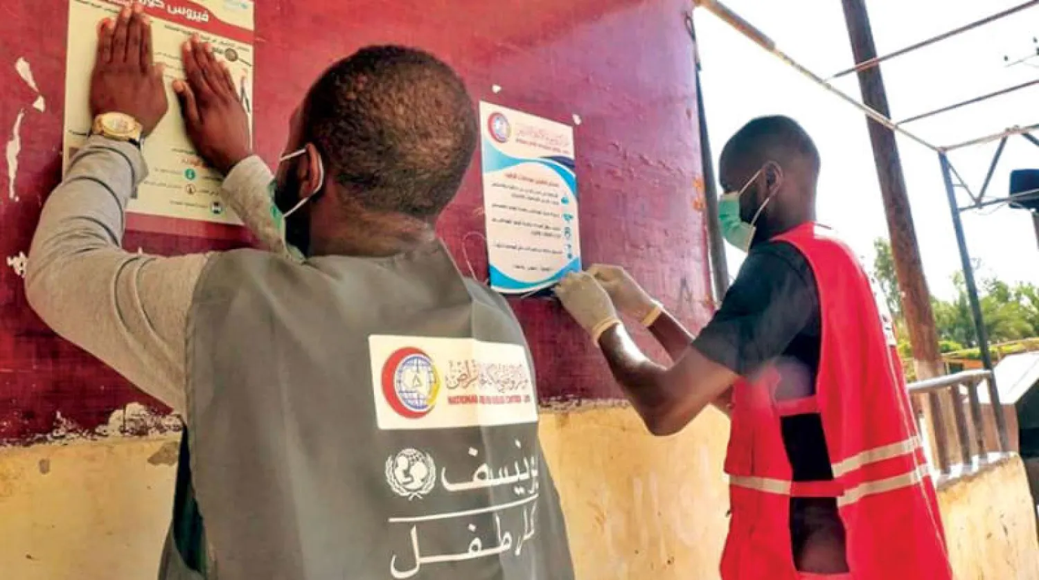 متطوعو «الهلال الأحمر الليبي» يعلقون ملصقات توعوية في بلدية غات (المركز الوطني)