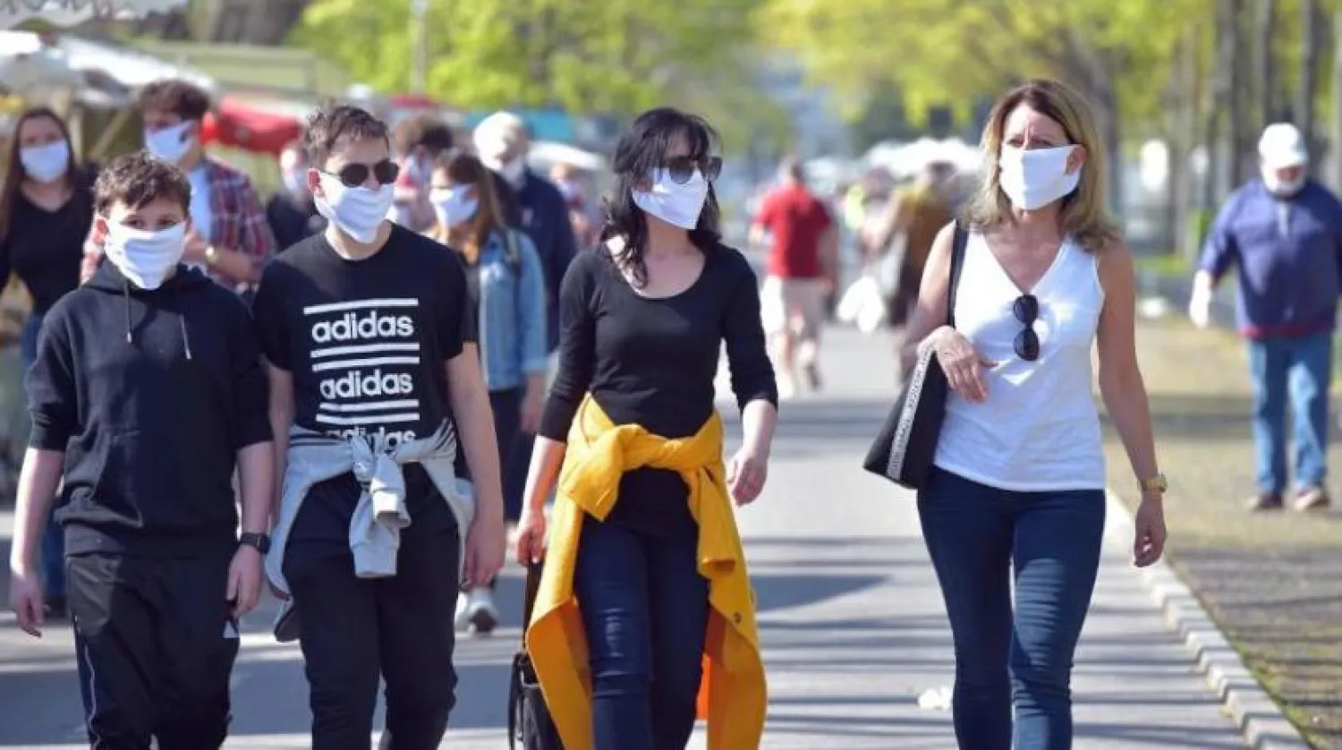 Almanya'nın Dresden kentinde vatandaşlar, popüler bir pazarı ziyaret ederken maske takıyor (Arşiv - Reuters)
