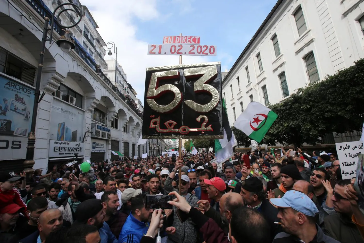 Demonstrators carry a banner during anti-government protests to mark year of revolution (Reuters)
