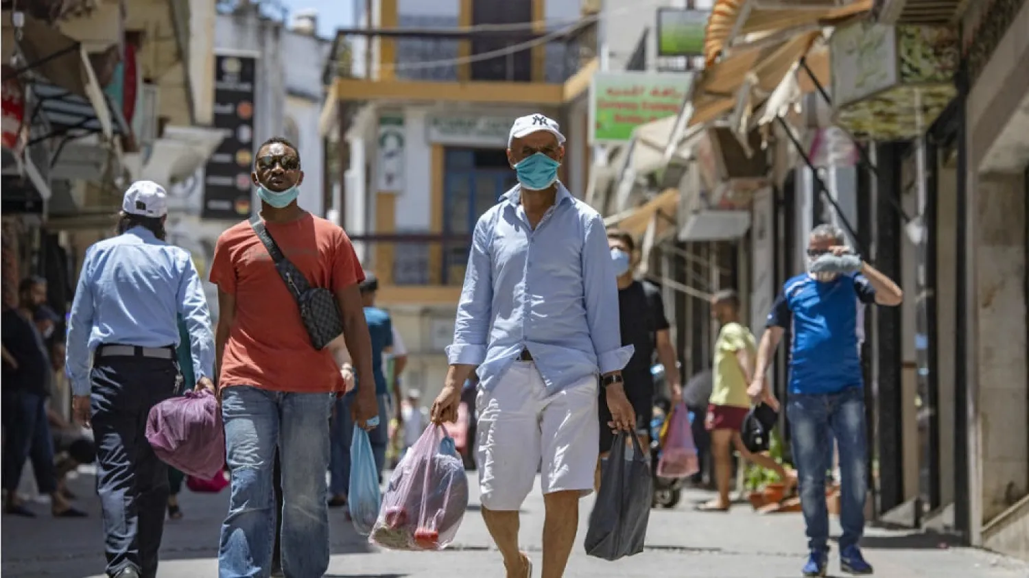 Moroccan men, wearing a protective face masks, in a street in Tangiers' Old City. (AFP)
