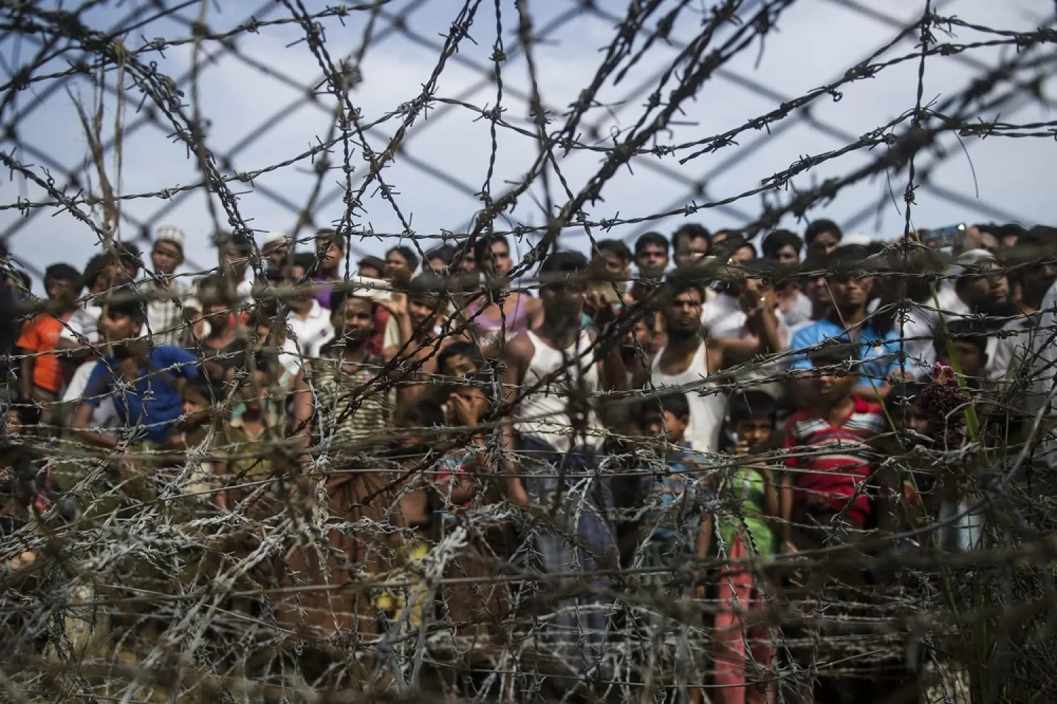 Rohingya refugees gather behind a barbed-wire fence in the ‘no-man’s land’ border zone between Myanmar and Bangladesh, April 25, 2018. (Getty Images)