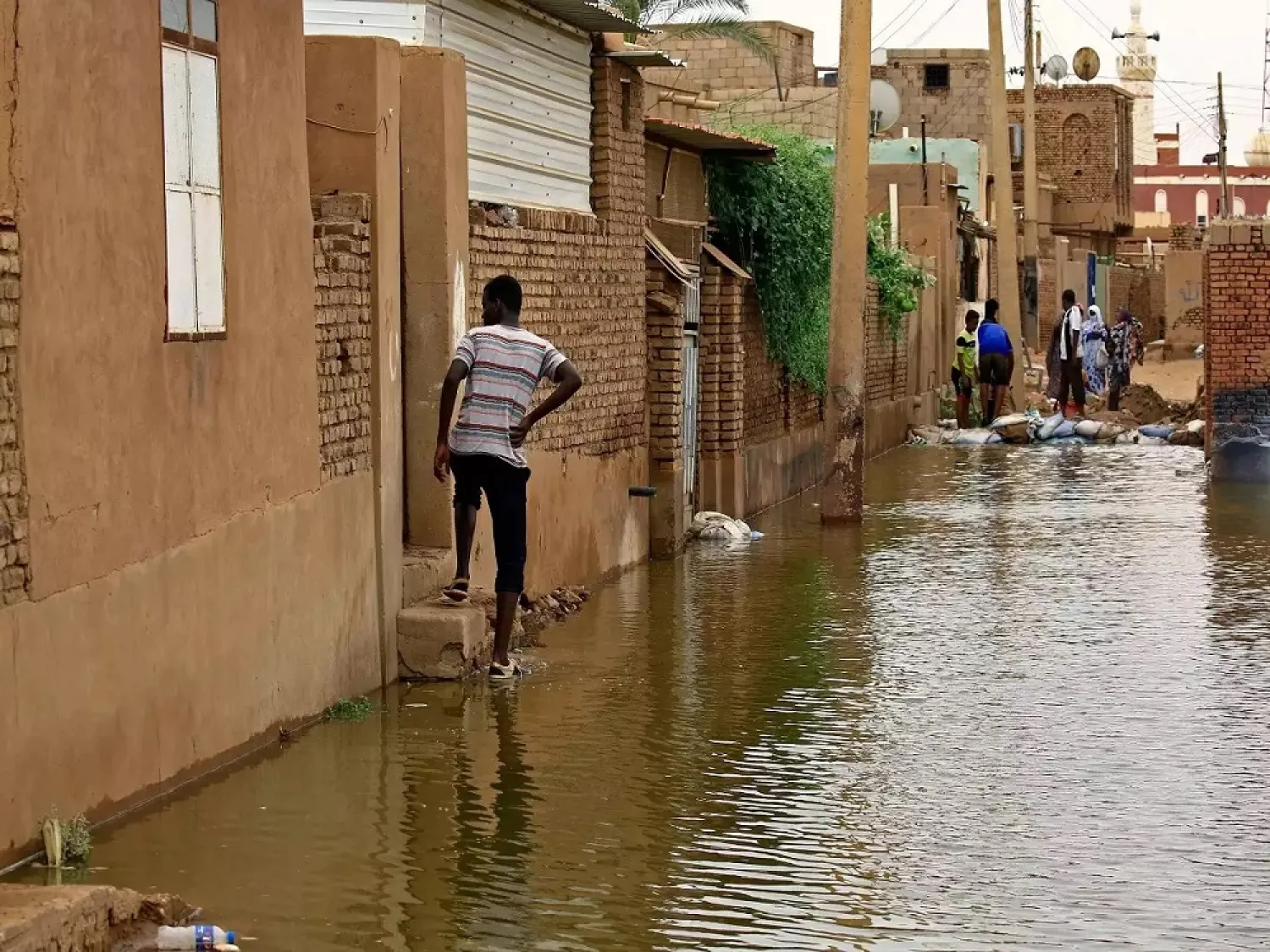 Sudanese men walk amidst flood waters on Tuti island where the Blue and White Nile converge in Khartoum. (AFP)