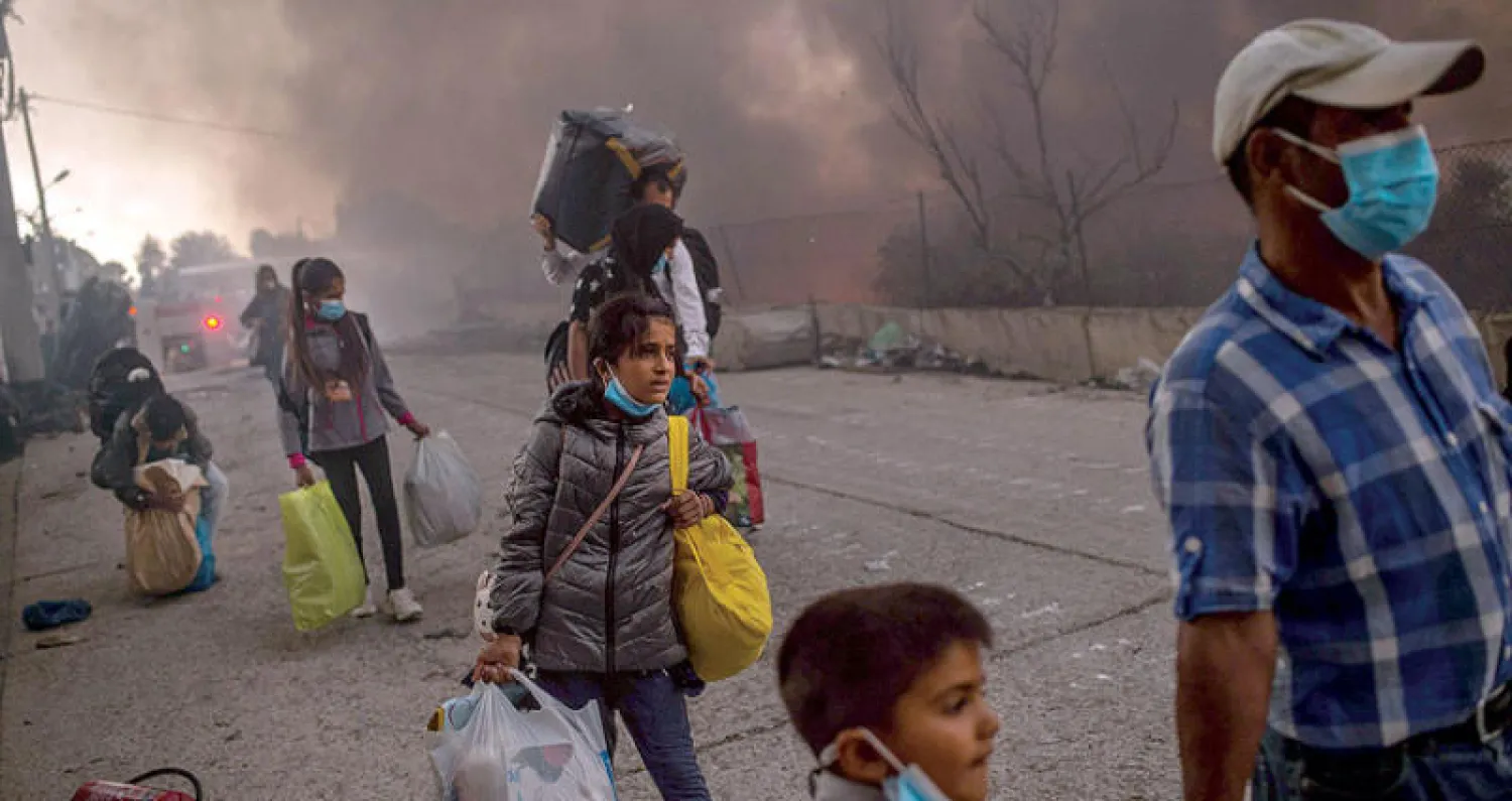 آلاف اللاجئين فقدوا المأوى بعد حريق التهم مخيمهم في جزيرة ليسبوس باليونان (أ.ف.ب)