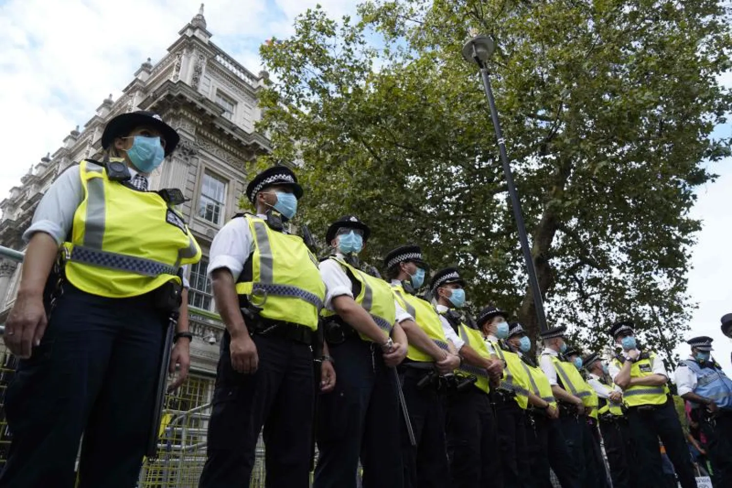عناصر من الشرطة البريطانية ترتدي الكمامات خلال تظاهرة وسط لندن (أ.ف.ب)