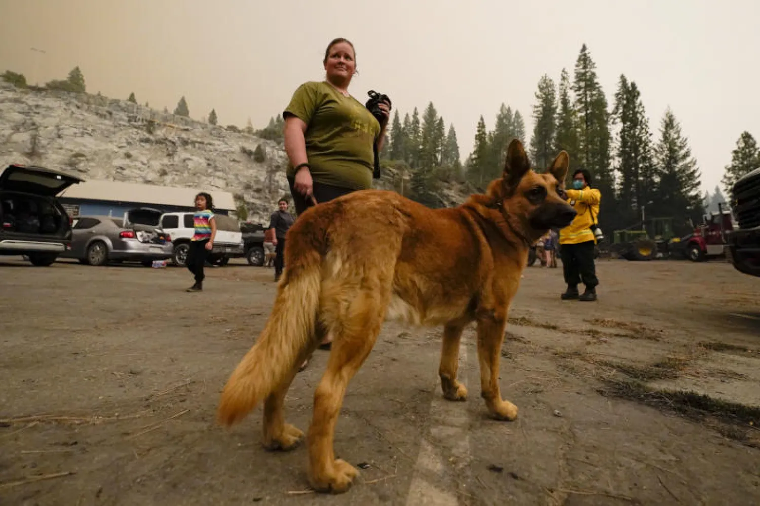 امرأة تقف إلى جانب كلبها في ولاية كاليفورنيا الأميركية (أ.ب)