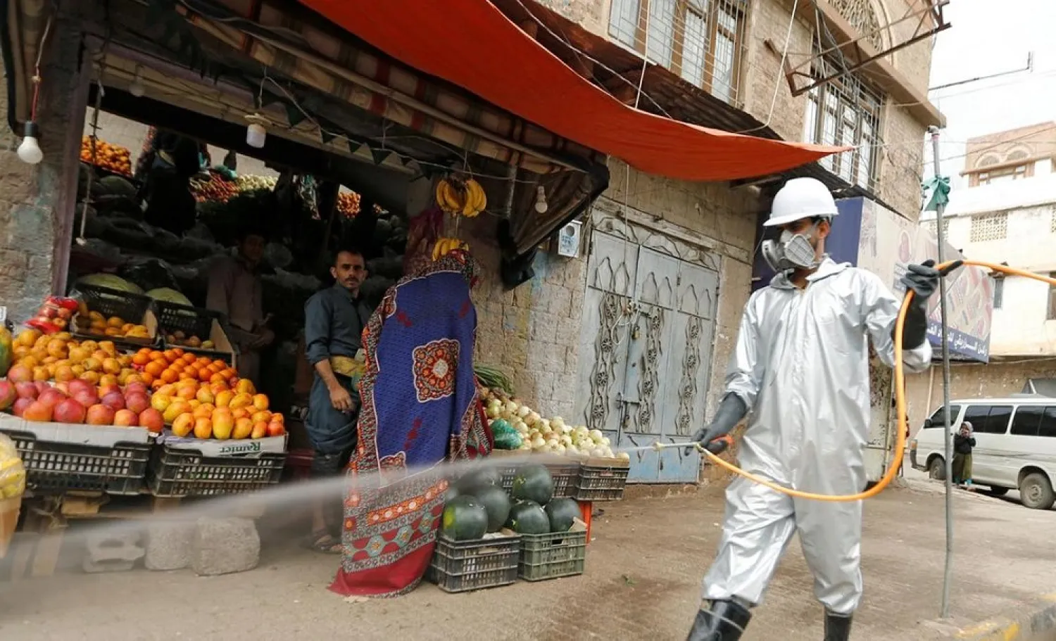 A health worker wearing a protective suit disinfects a market amid concerns of the spread of the coronavirus, in Sanaa, Yemen. (Reuters)