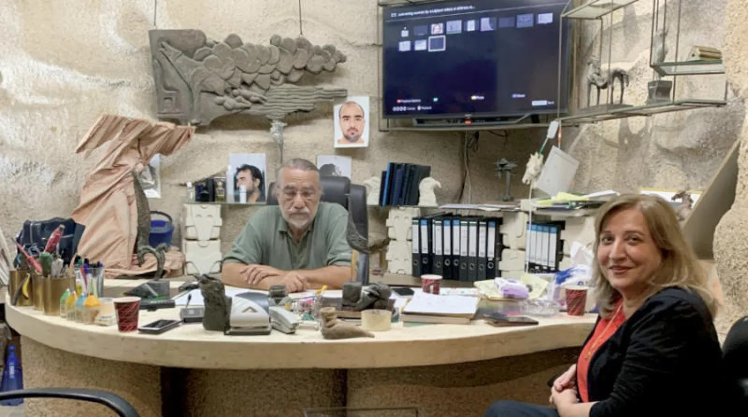 الأخرس في مرسمه مع زوجته قمر دروبي التي شاركت ببعض الأعمال