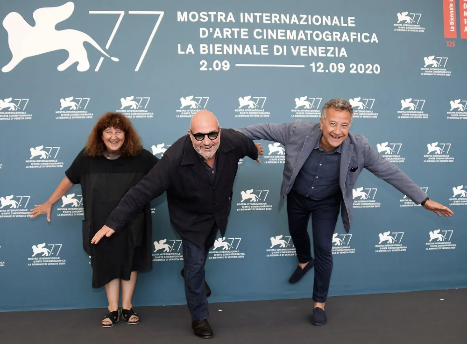 Italian filmmaker Gianfranco Rosi (C), Italian producers Donatella Palermo (L) and Paolo Del Brocco (R), pose at a photocall for ‘Notturno’ during the Venice film festival, in Venice, Italy, Sept. 8, 2020. (EPA)