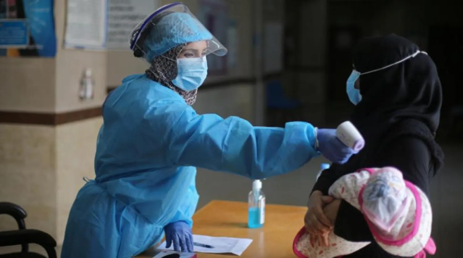 Gazze’de Birleşmiş Milletler tarafından işletilen bir klinikte görevli hemşire yeni doğmuş bir bebeğin ateşini ölçüyor (Reuters)