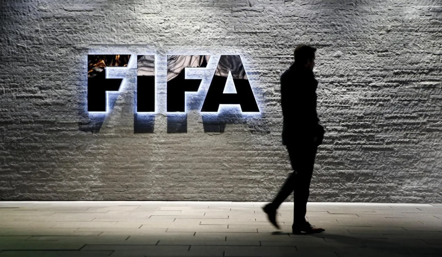 A journalist walks in front of FIFA's headquarters in Zurich, Switzerland December 2, 2015. REUTERS/Arnd Wiegmann
