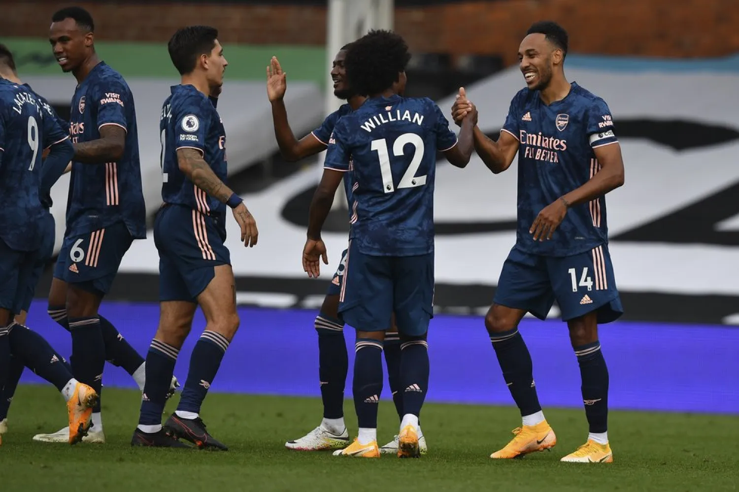 Arsenal's Pierre-Emerick Aubameyang, right, is cheered by teammates after scoring during the English Premier League match between Fulham and Arsenal in London, Sept. 12, 2020. (AP)