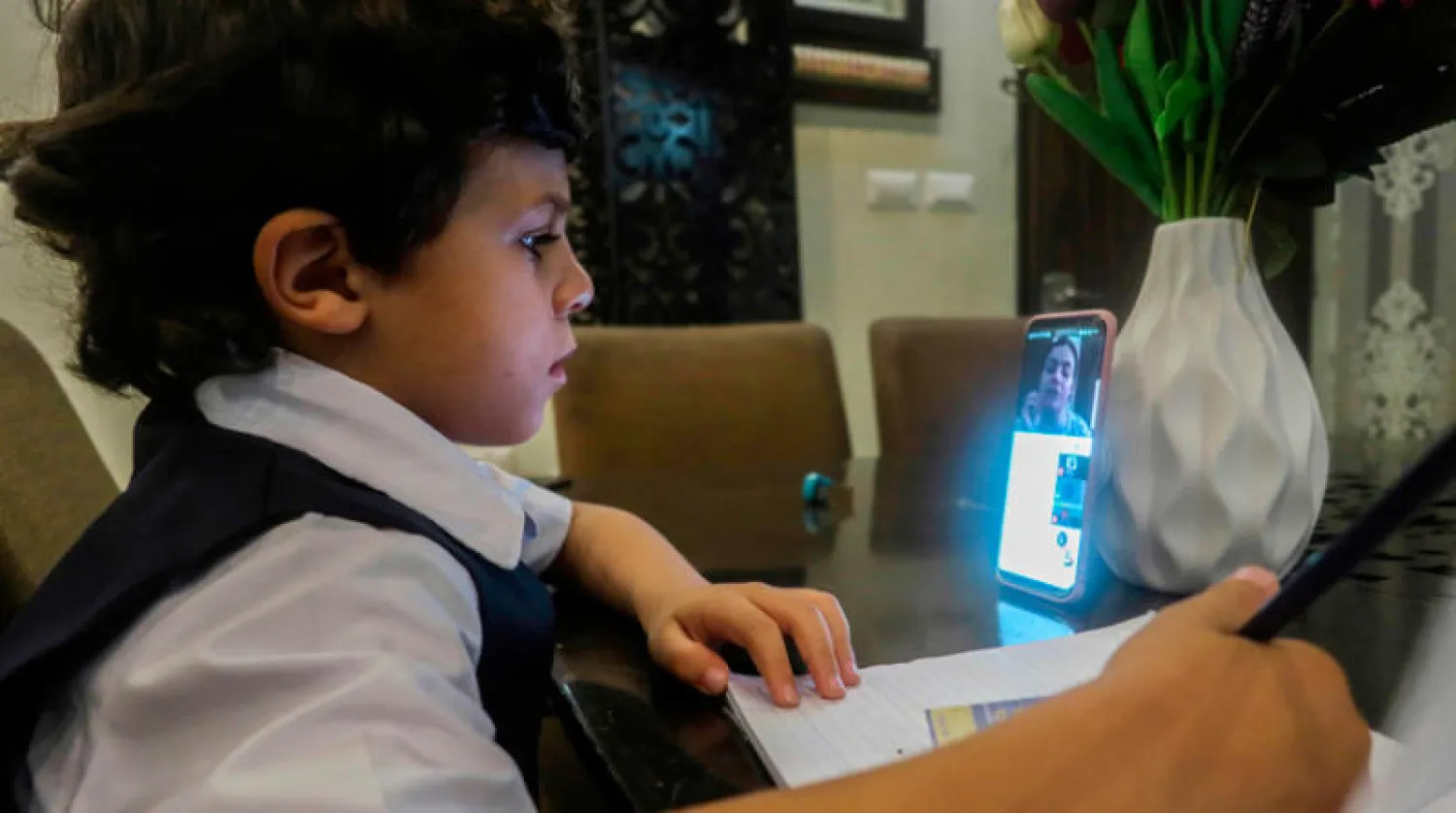 فلسطيني يحضر درساً عبر الإنترنت في غزة (أ.ف.ب)