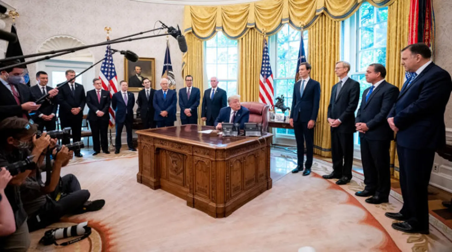الرئيس ترمب محاطاً بمساعديه خلال إعلانه الاتفاق بين البحرين وإسرائيل في البيت الأبيض أول من أمس (د.ب.أ)