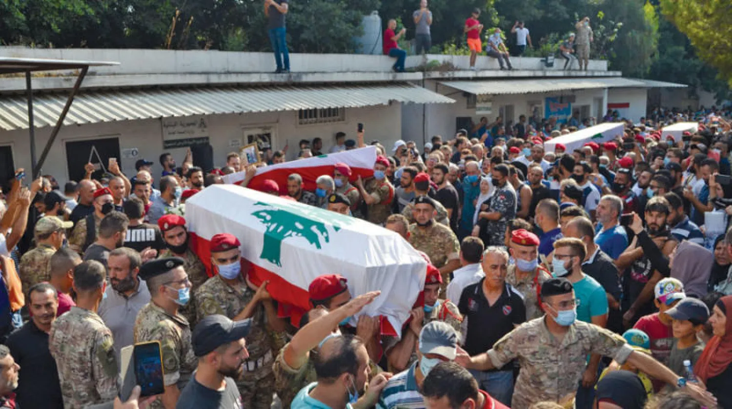 جنود لبنانيون يحملون نعوش أربعة من رفاقهم قتلوا في مواجهة مع مجموعة مسلحة في طرابلس أمس (أ.ف.ب)